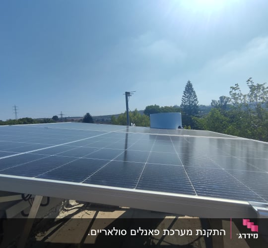 פאנלים סולאריים מותקנים על גג תחת שמש בהירה